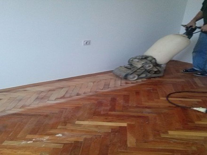 Majstor hobluje parket profesionalnom mašinom